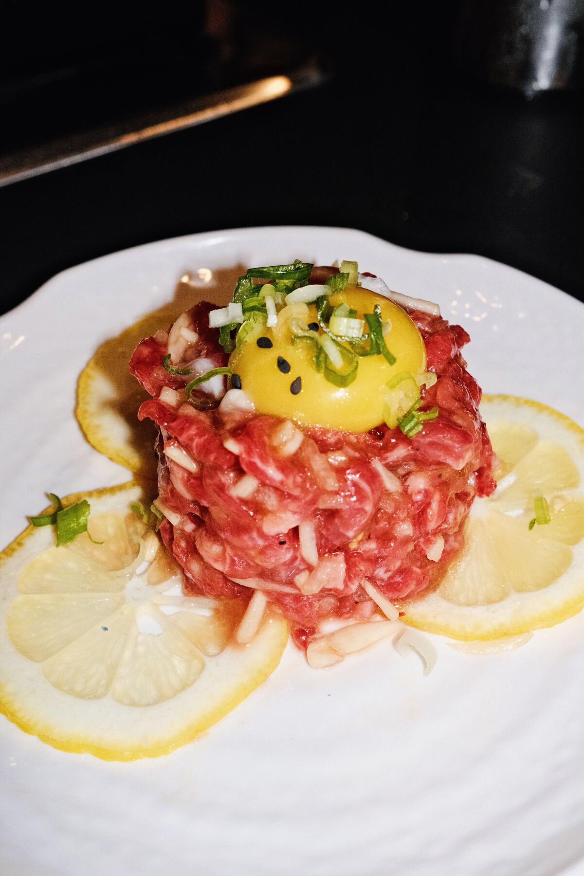 A cylinder of Wagyu tartare topped with a whole egg yolk at Moohan Korean BBQ in Koreatown