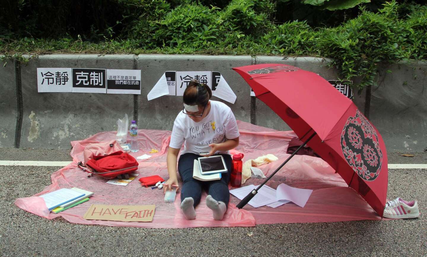 A pro-democracy protestor sits in the road near the Hong Kong government headquarters.