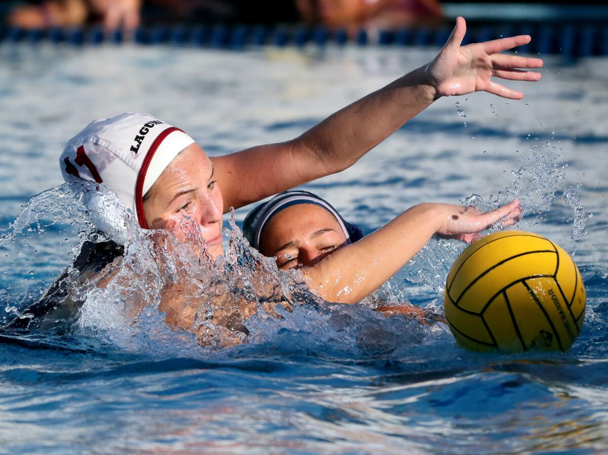 Laguna Beach High water polo player Emma Singer, left, goes for a steal from Newport's Avery Montiel.