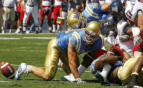UCLA linebacker Korey Bosworth spots the football after a tackle by Bruins linebacker forced Arizona running back Nic Grigsby to fumble in the first half Saturday.