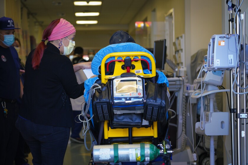 El personal de la sala de emergencias revisa a un paciente transportado en ambulancia