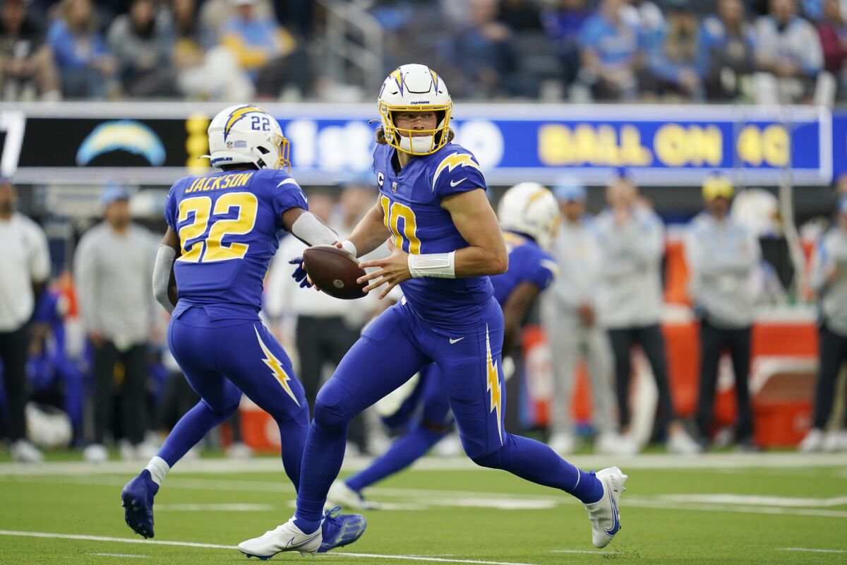 Los Angeles Chargers quarterback Justin Herbert rolls out during the first half.
