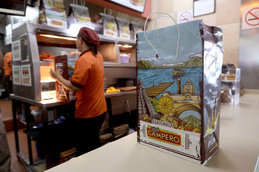 A worker packs a bag at Pollo Compero.