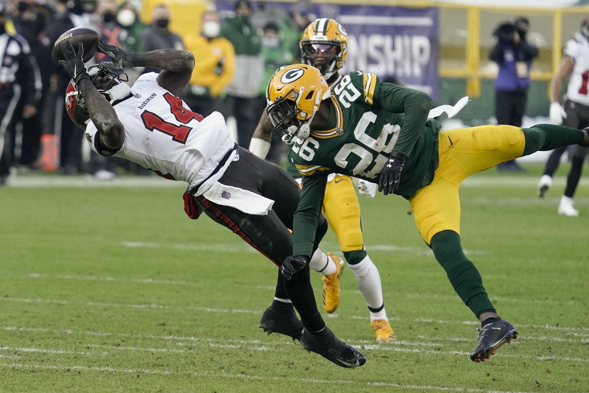 Tampa Bay Buccaneers' Chris Godwin (14) catches a pass against Green Bay Packers' Darnell Savage (26).