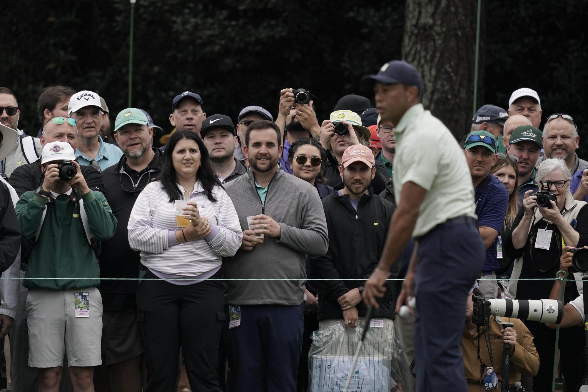 Spectators watch Tiger Woods on the driving range 