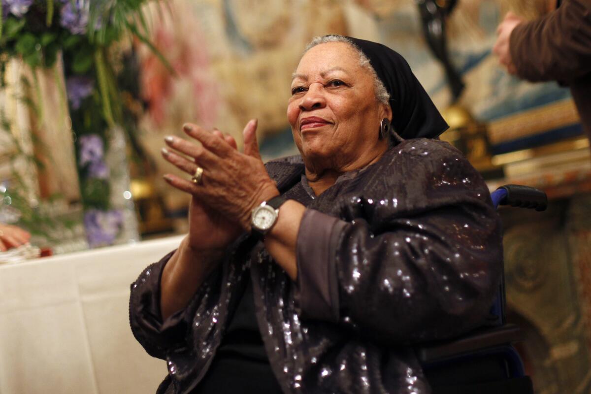 Toni Morrison sits and claps at a literary event.  