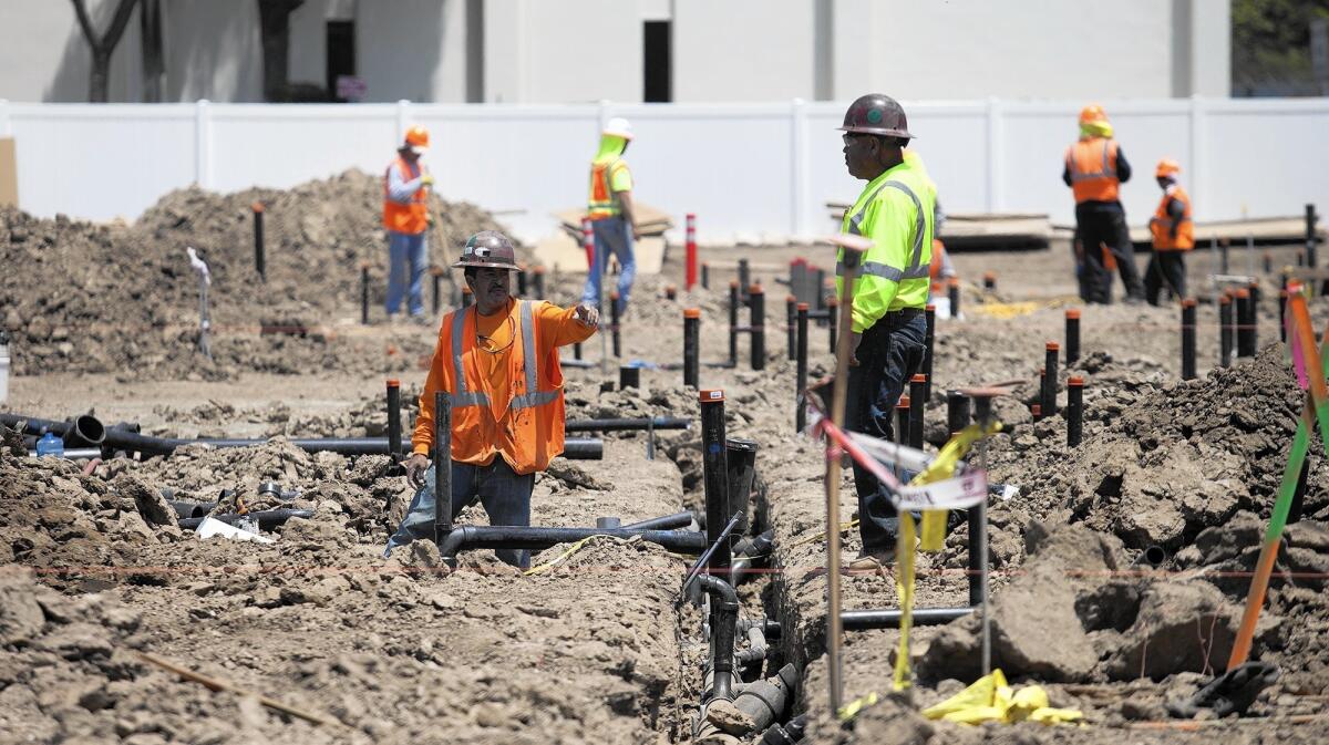 Workers at the construction site for Baker Block, a 240-unit apartment complex in Costa Mesa, in 2016.
