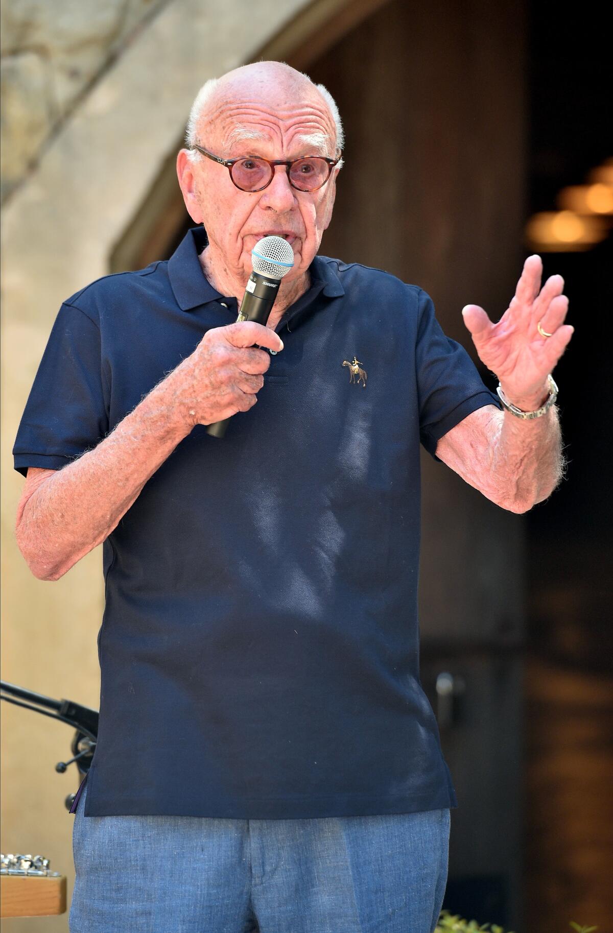 Rupert Murdoch in a polo shirt and jeans with a microphone at his Bel-Air winery's 30th anniversary party.