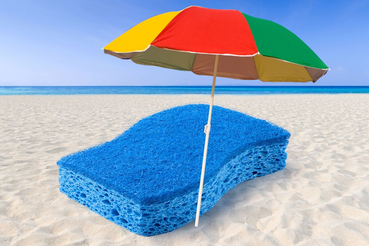 Photo illustration of a beach with rainbow umbrella and a sponge in place of a towel.