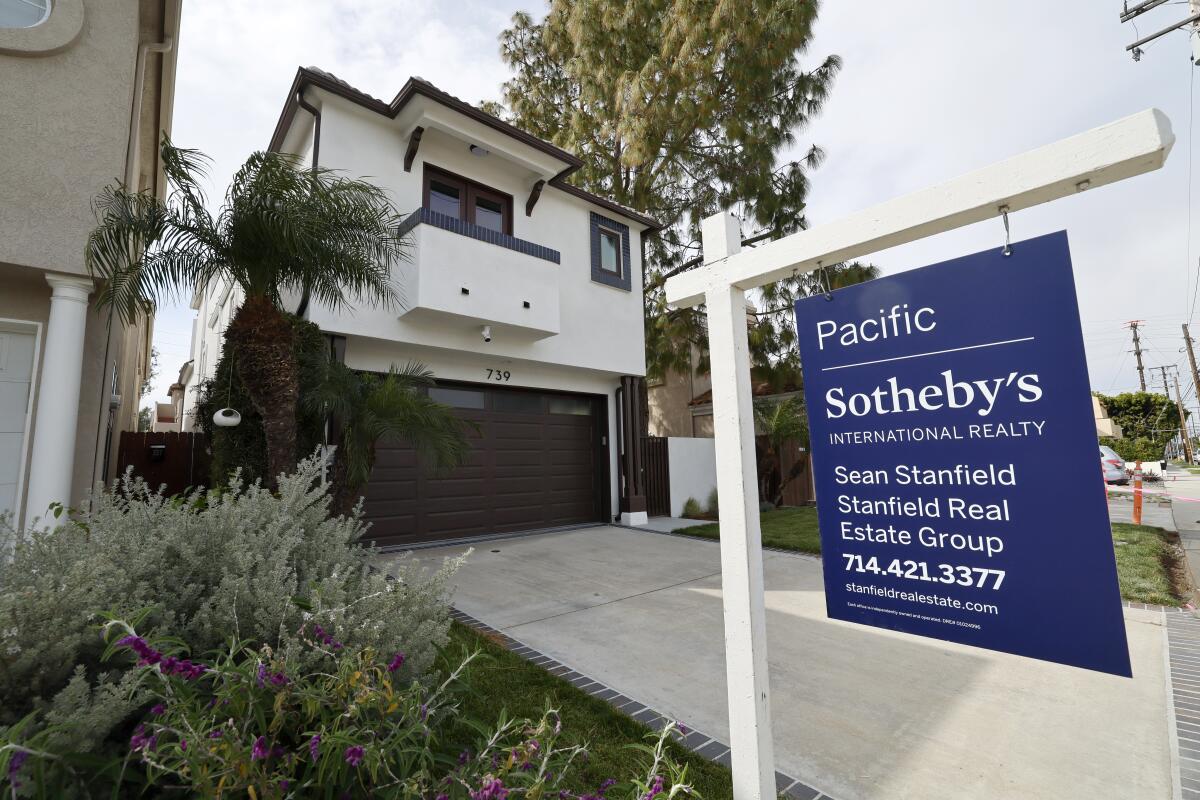 A for-sale sign in front of a house in Huntington Beach.