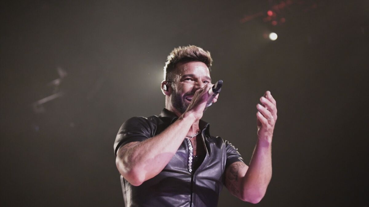 The singer Ricky Martin holds a microphone