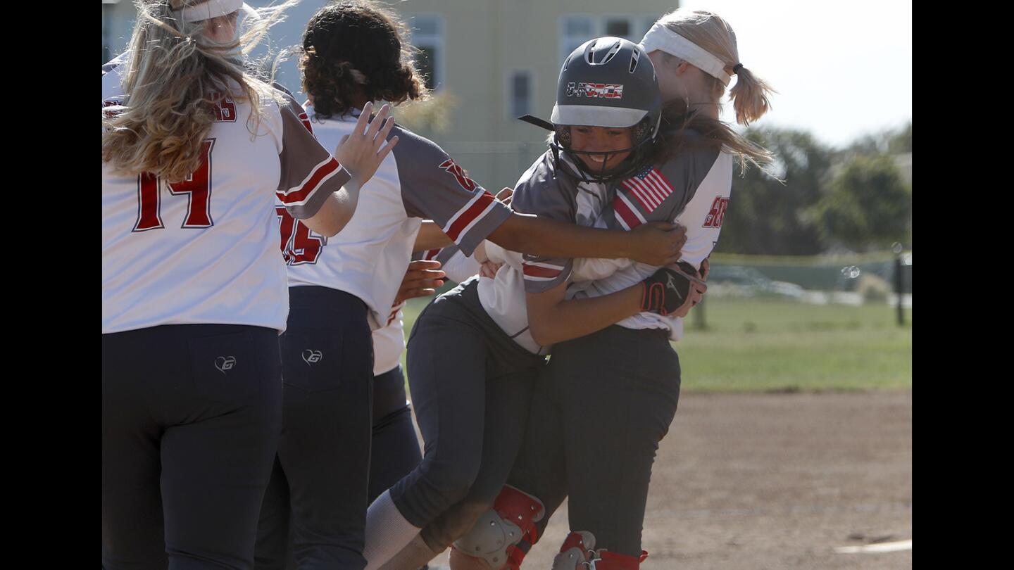 Ocean View High's Ari Hencke celebrates with teammates after scoring the winning run against Goleta Dos Pueblos during the seventh inning in the wild-card round of the CIF Southern Section Division 5 playoffs in Huntington Beach on Tuesday, May 15.