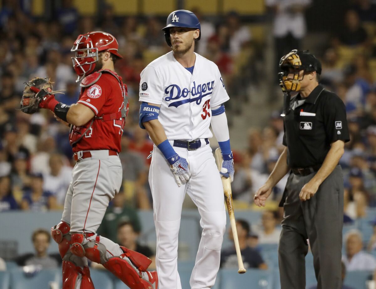 Dodgers right fielder Cody Bellinger walks back to the dugout after striking out against the Angels in the eighth inning on Wednesday at Dodger Stadium.