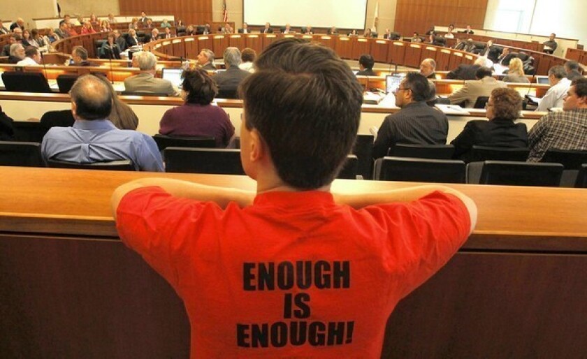 A member of the California Faculty Assn. wears a protest slogan during a meeting of the California State University Board of Trustees in July. Next week, the board will consider imposing a series of new student fees in fall 2013.