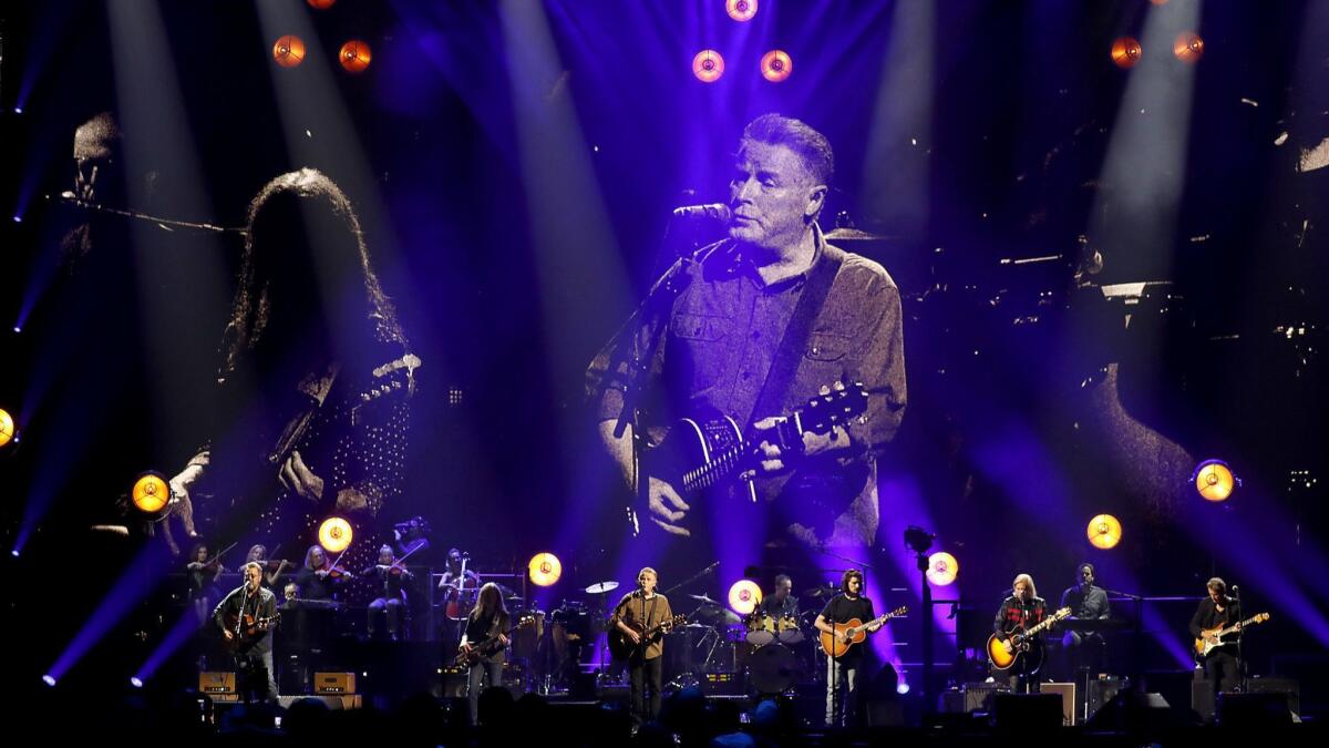 Don Henley, projected onscreen as he plays onstage with the Eagles at the Forum.