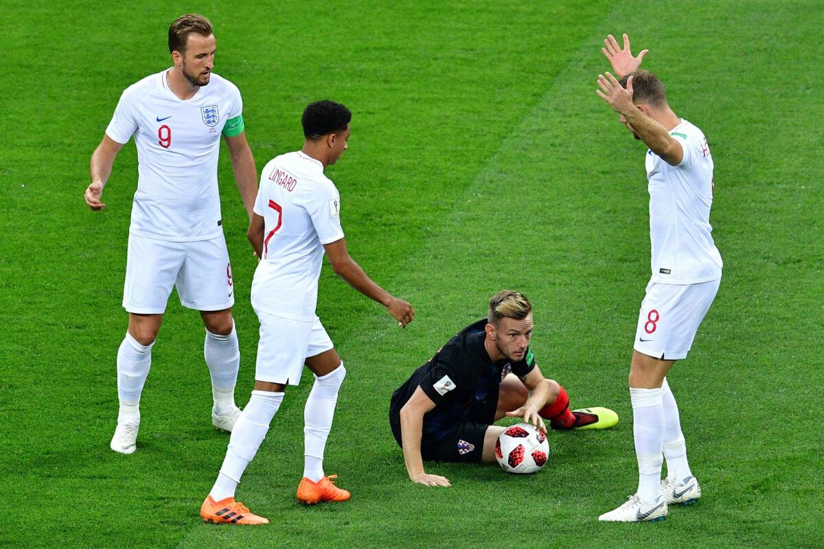 Croatia's midfielder Ivan Rakitic (2R) reacts on the ground next to England's midfielder Jordan Henderson (R), England's midfielder Jesse Lingard (2L) and England's forward Harry Kane (L) during the Russia 2018 World Cup semi-final football match between Croatia and England at the Luzhniki Stadium in Moscow on July 11, 2018.
