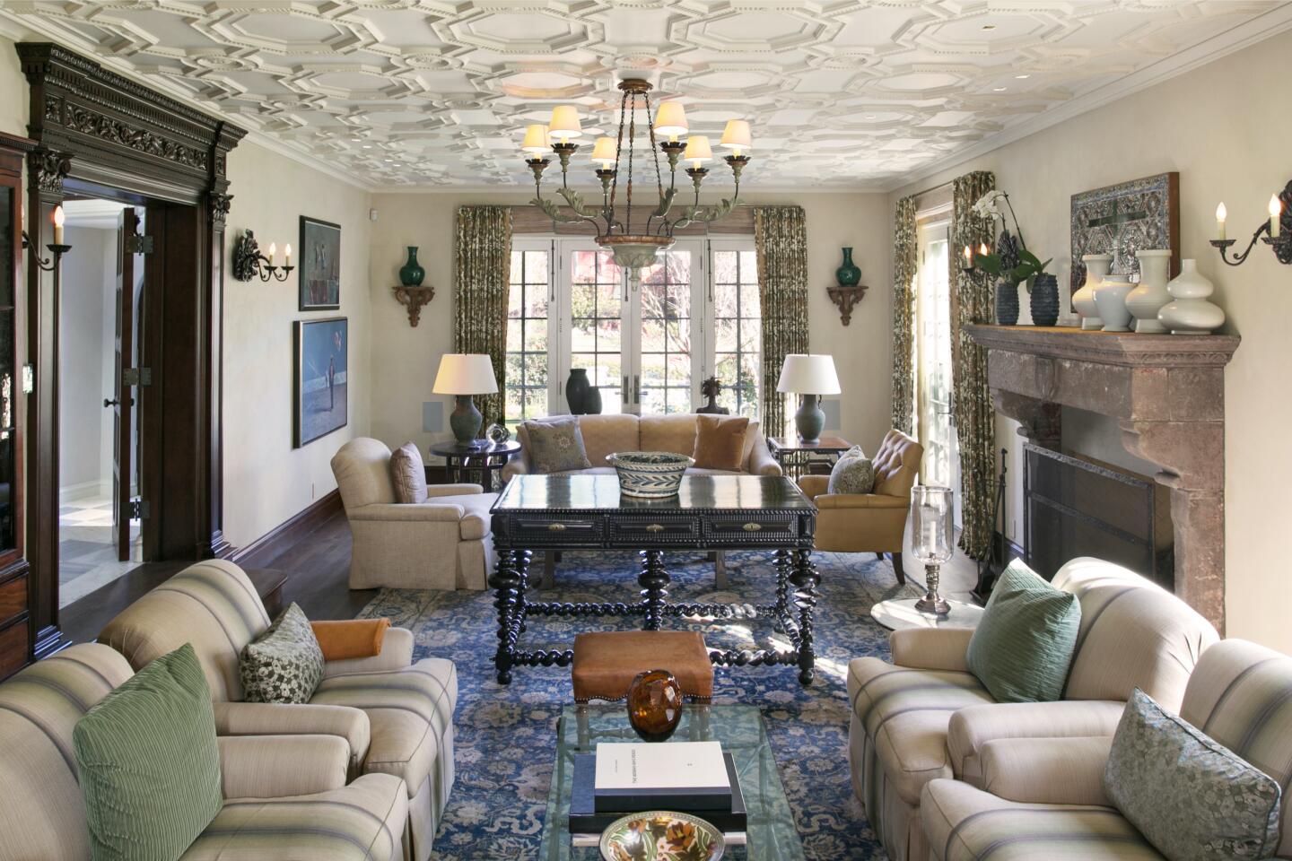 The living room is furnished and has windows and blue carpeting.