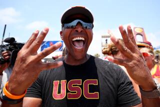 USC coach Dain Blanton holds up four fingers to celebrate the Trojans winning their fourth beach national title
