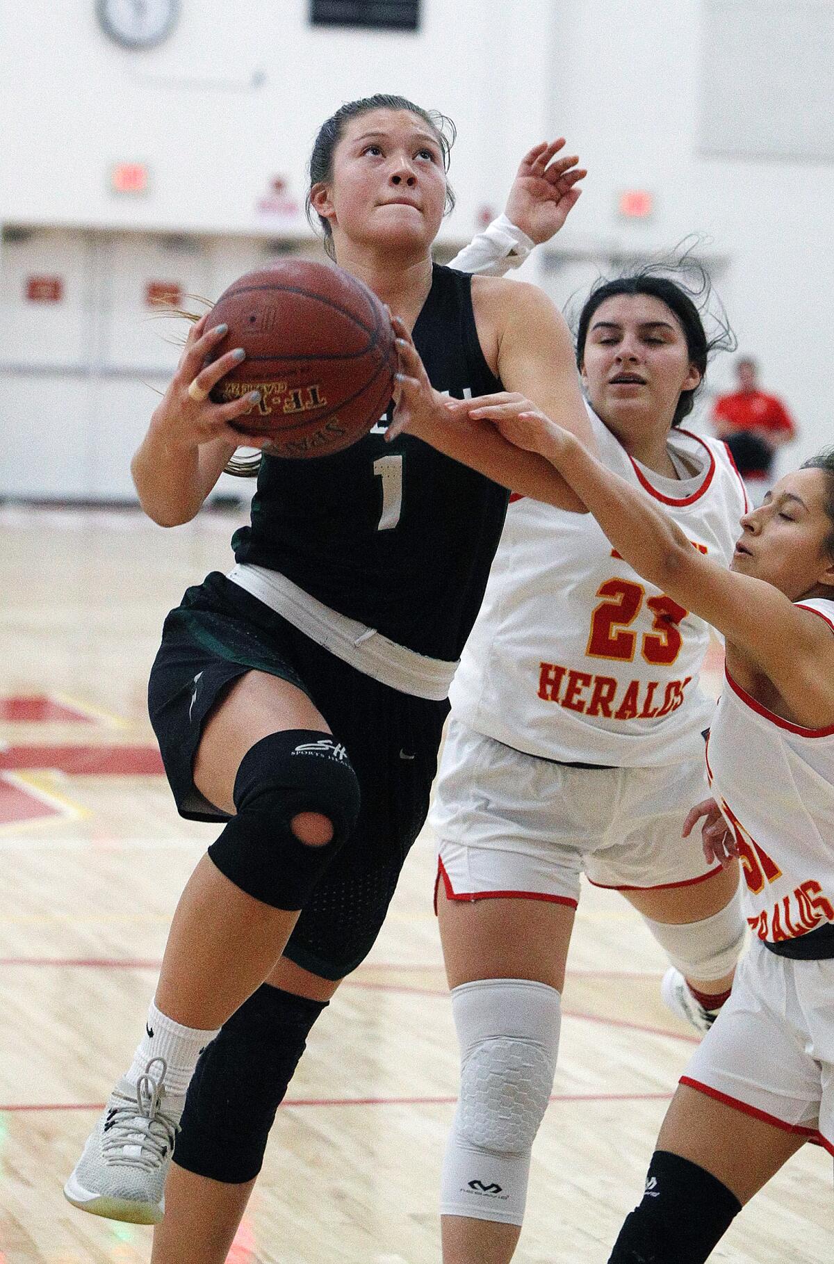 Sage Hill's Emily Elliott (1) drives to the basket against Whittier Christian's Shelly Vasquez (23) and Juliette Corona in a nonleague game on Thursday in La Habra.