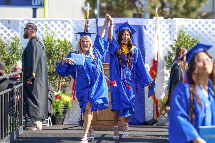 Fountain Valley graduates celebrate with their diplomas during a commencement ceremony on Wednesday at Orange Coast College