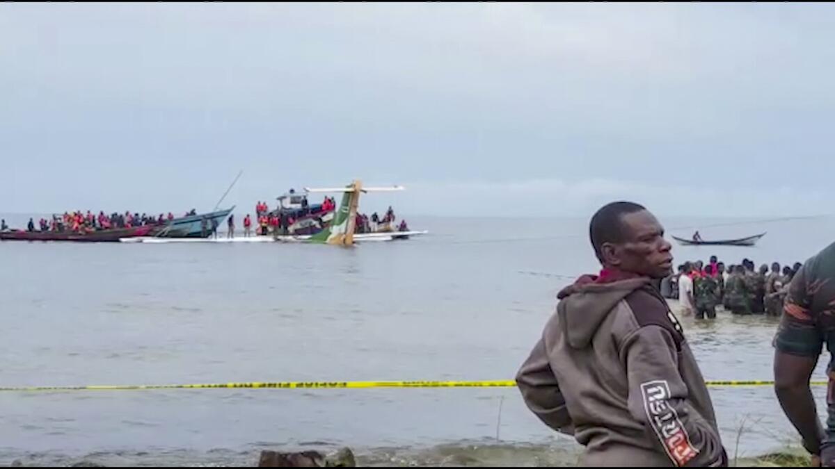 Rescuers in boats are seen around the tail fin of a crashed Precision Air passenger aircraft on the shores of Lake Victoria in Bukoba, in western Tanzania Sunday, Nov. 6, 2022. The small passenger plane crashed Sunday morning into Lake Victoria near Bukoba airport and the company Precision Air said the flight was coming from the coastal city of Dar es Salaam, though it was not immediately clear how many people were on board. (AYO TV via AP)