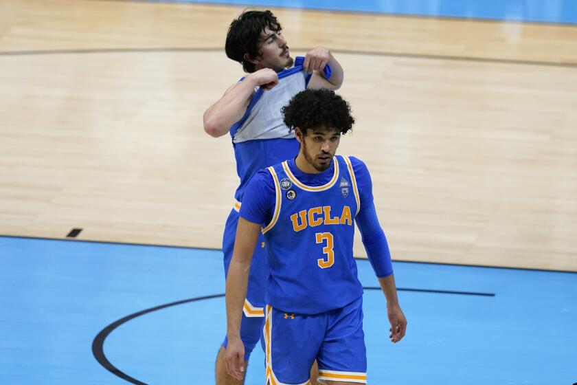 UCLA guards Johnny Juzang (3) and Jaime Jaquez Jr. walk off the court after losing in overtime to Gonzaga in the Final Four.