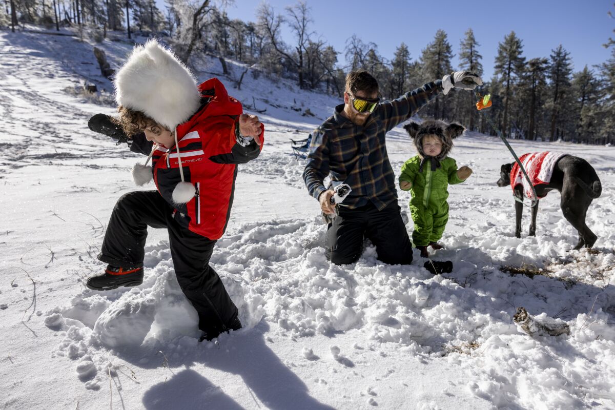 Conor O'Donoghue, from Carmel Valley, plays in the snow with his son Liam, daughter Magnolia, and their dog Bailey.