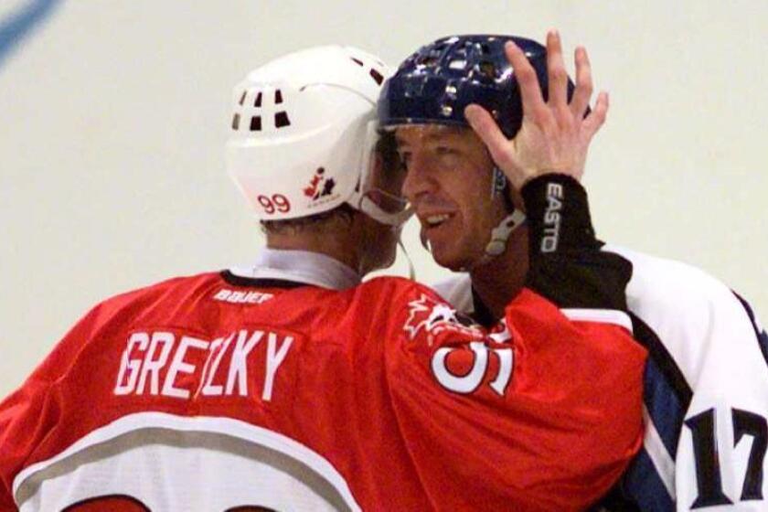 Wayne Getzky of Team Canada and Jari Kurri of Team Finland embrace after Finland's 3–2 victory over Canada at the 1998 Olympic Games.