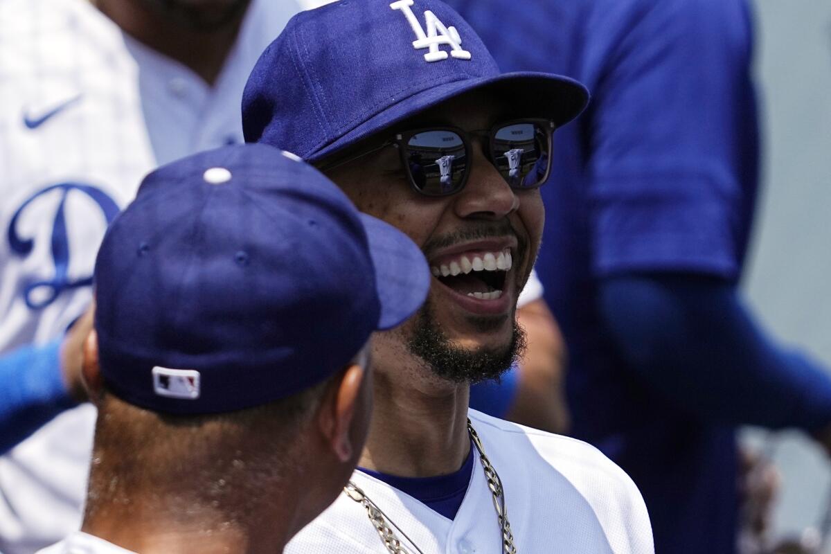 Dodgers right fielder Mookie Betts laughs as he talks to manager Dave Roberts.