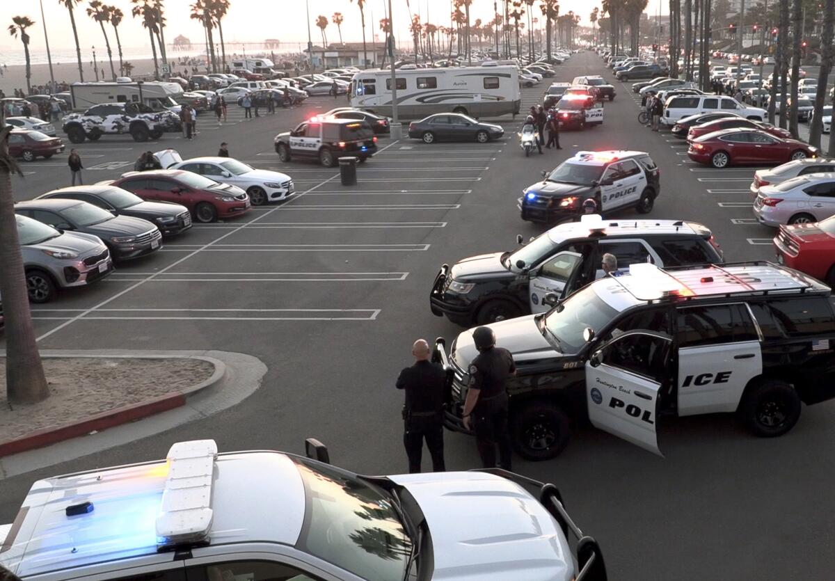 Huntington Beach police stage in the parking lot near Lifeguard Tower 13.