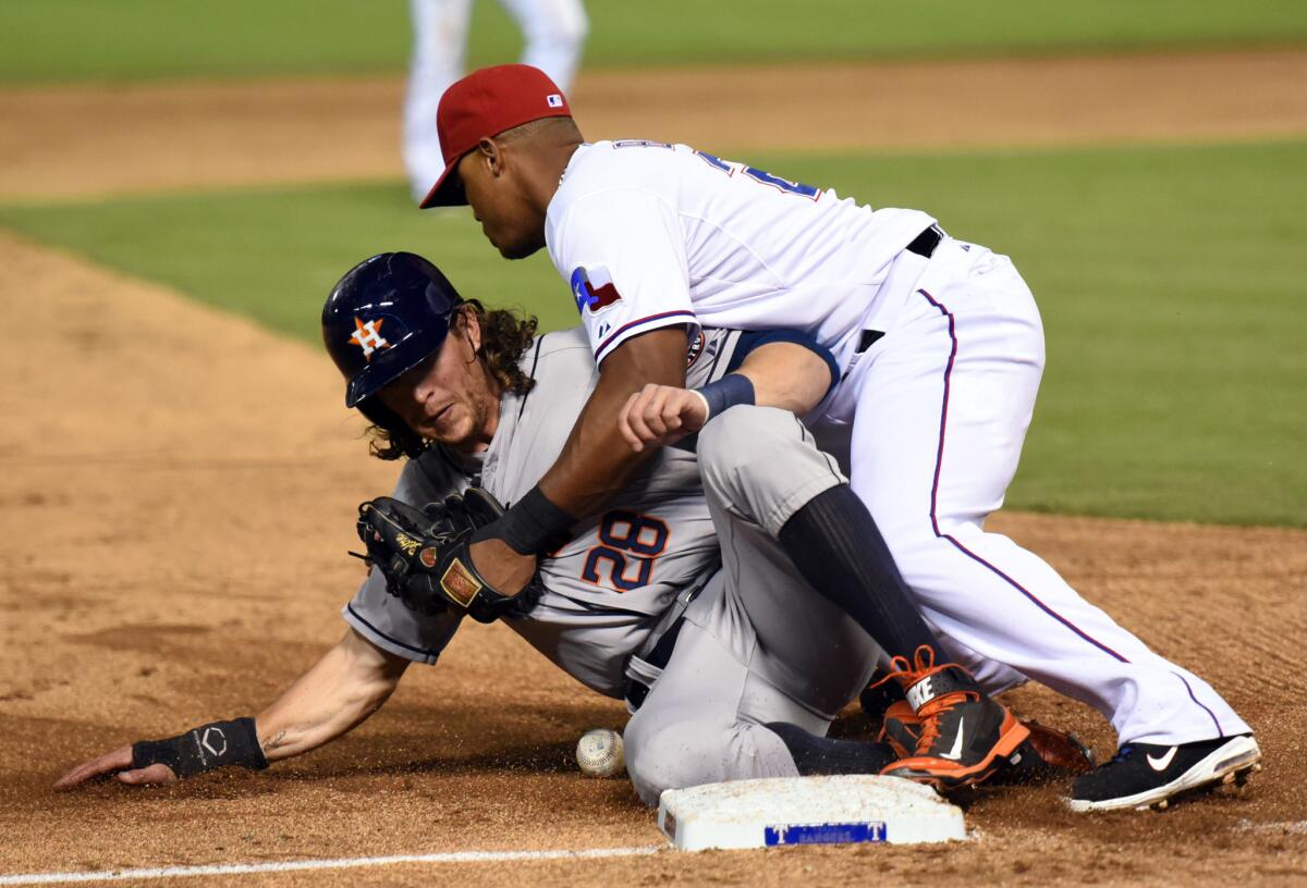 Houston's Colby Rasmus is safe at third under Texas' Adrian Beltre on Monday night.