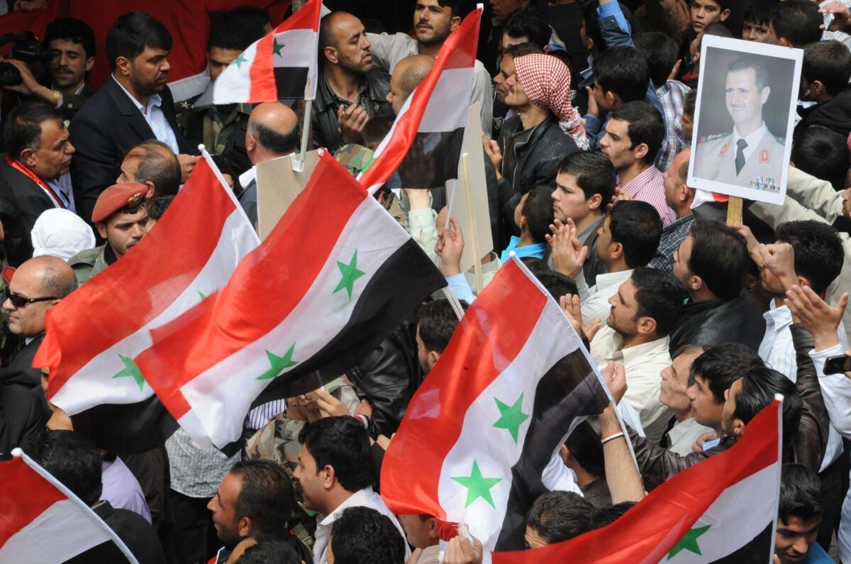 Syrians demonstrate support for President Bashar Assad in an image released by the official Syrian Arab News Agency.