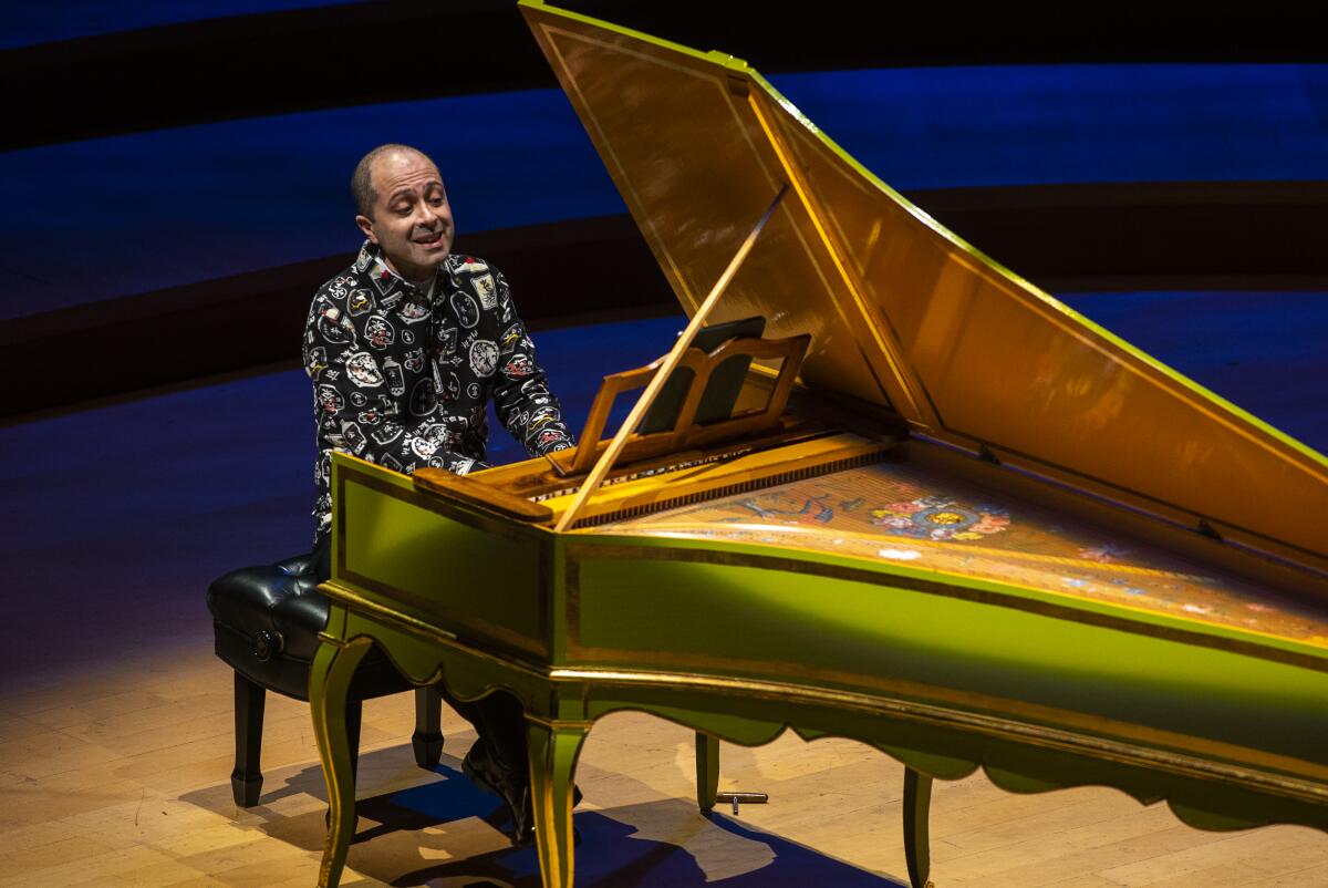 A man plays the harpsichord on a stage 