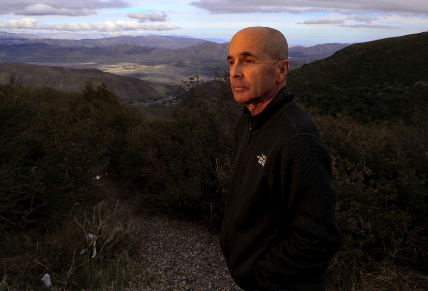 Novelist Don Winslow stands on a hilltop in San Diego County.
