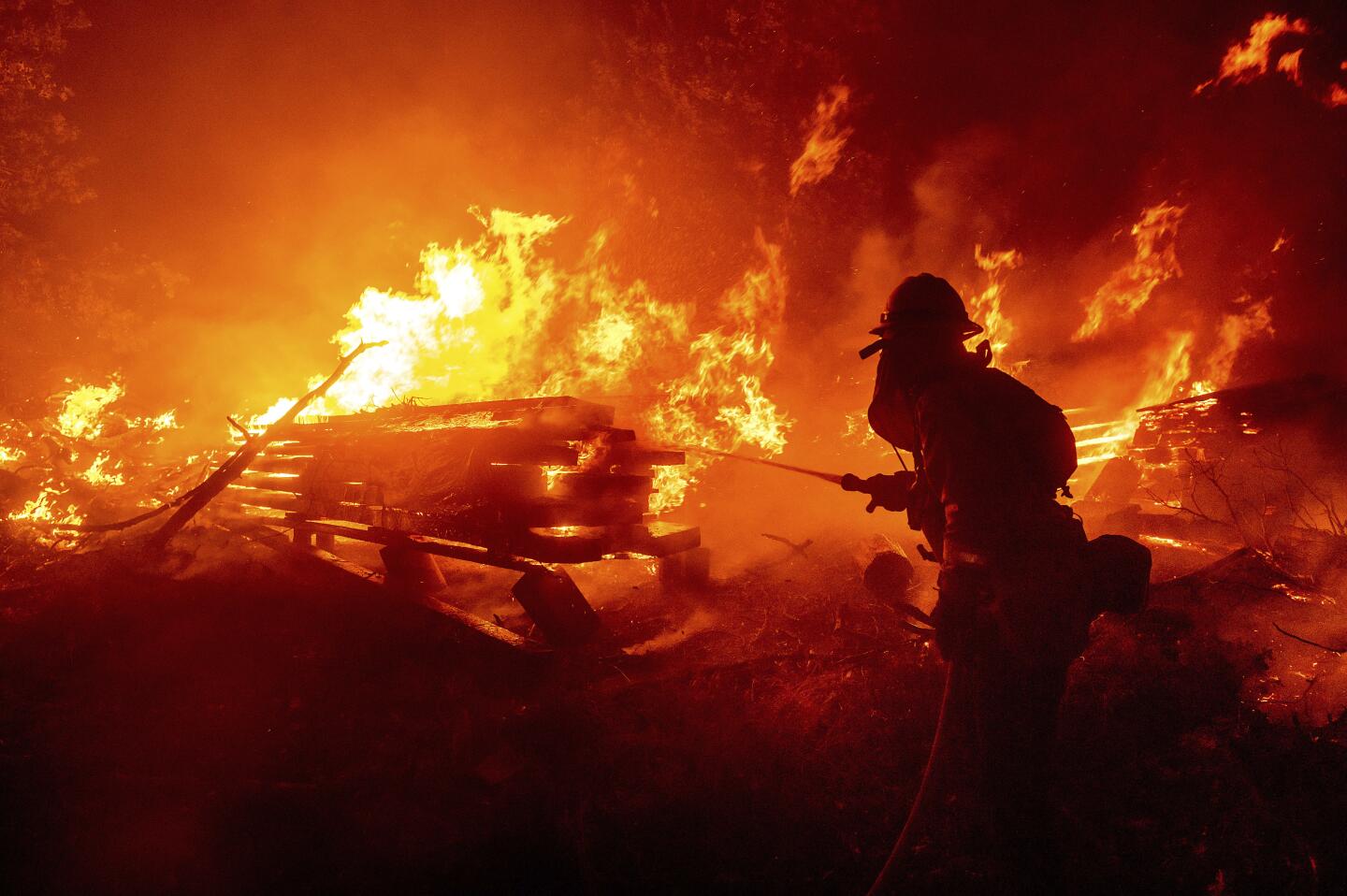 A firefighter battles the Creek fire as it threatens homes in Madera County.