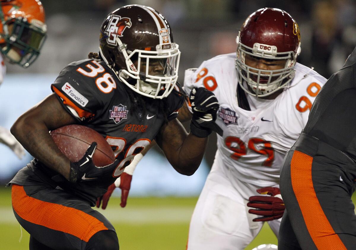 National team running back Travis Greene (38), of Bowling Green, runs against American team defensive lineman Antwaun Woods (99), of USC, during the second half of the NFLPA Collegiate Bowl in Carson on Jan. 23.