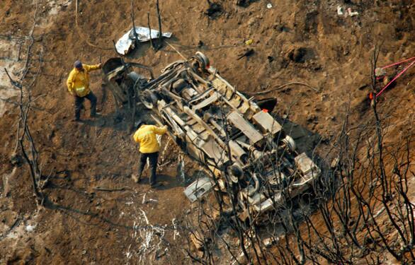 L.A. County fire investigators survey the vehicle that went off the road and fell nearly 1,000 feet down a steep ravine near Mt. Gleason in Angeles National Forest, killing county firefighters Tedmund Hall, 47, and Arnaldo Quinones, 34.