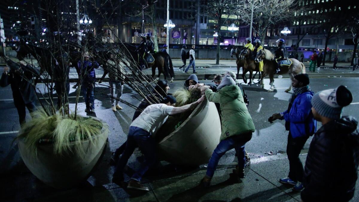 Fans grapple with huge plant pots in Philadelphia to celebrate the Eagles' victory in Super Bowl LII.