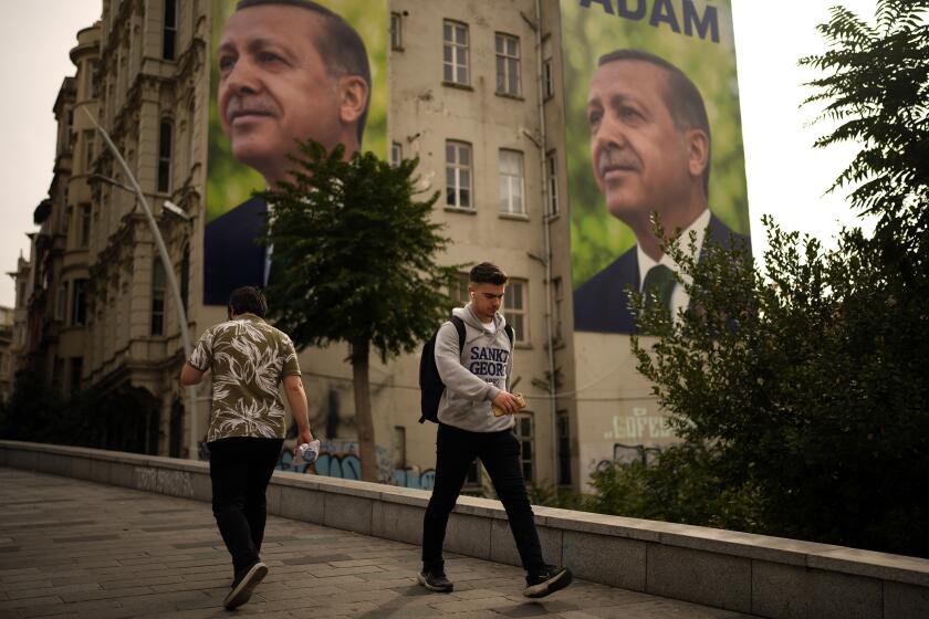 People walk next to a poster of Turkish President Recep Tayyip Erdogan in Istanbul, Wednesday, Oct. 25, 2023. Turkey is marking the 100th anniversary of the creation of the modern, secular Turkish Republic from the ruins of the Ottoman Empire on Sunday but without any grand pageantry or gala reception to memorialize the important milestone. (AP Photo/Emrah Gurel)