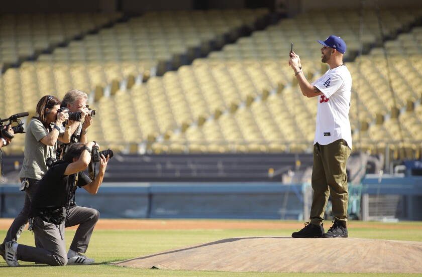 David Price is joined by photographers on the field after a news conference officially introducing him and teammate Mookie Betts on Feb. 12 at Dodger Stadium.