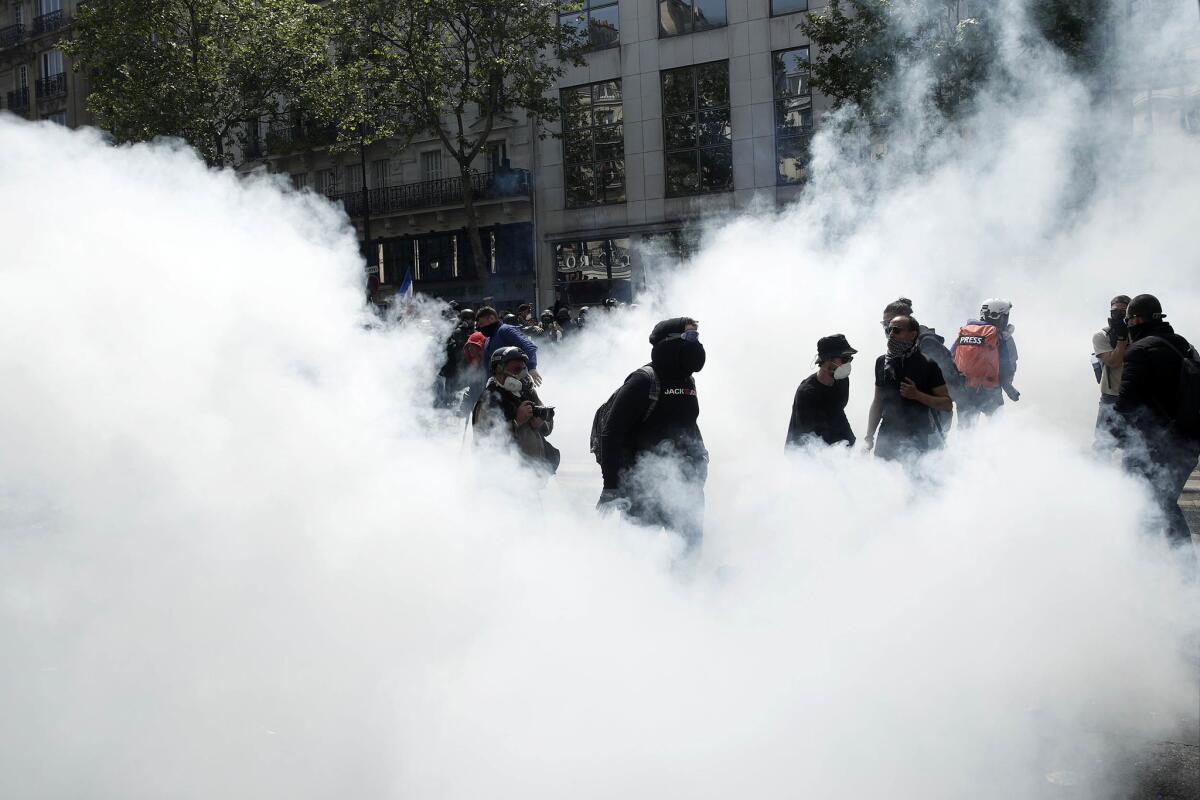 Protesters stand amid smoke during a demonstration marking Labor Day in Paris, France. (YOAN VALAT / EPA / Rex / Shutterstock)