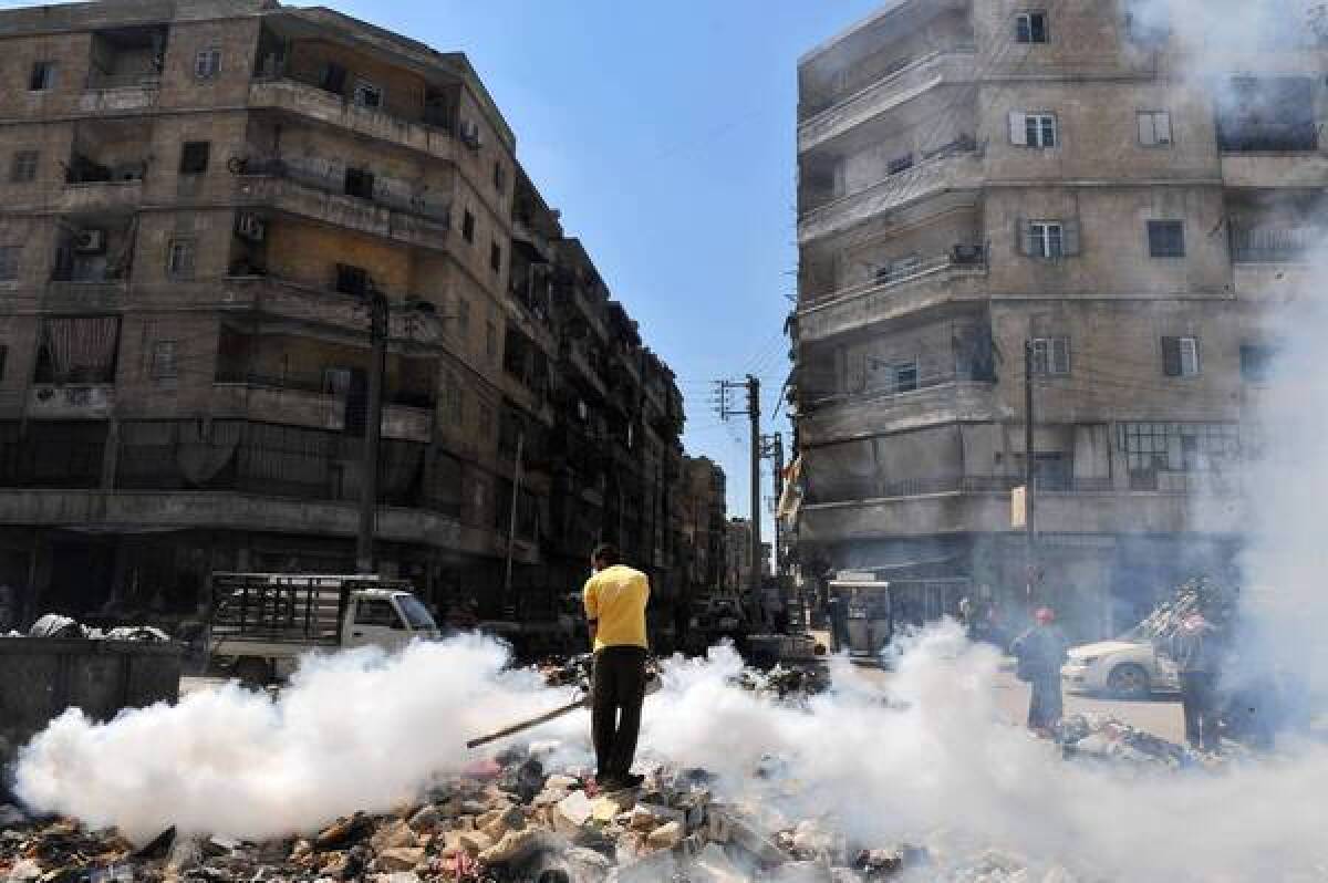 A man fumigates a street covered with uncollected garbage in Aleppo, northern Syria. Parts of the city are under opposition control while others remain in government hands.