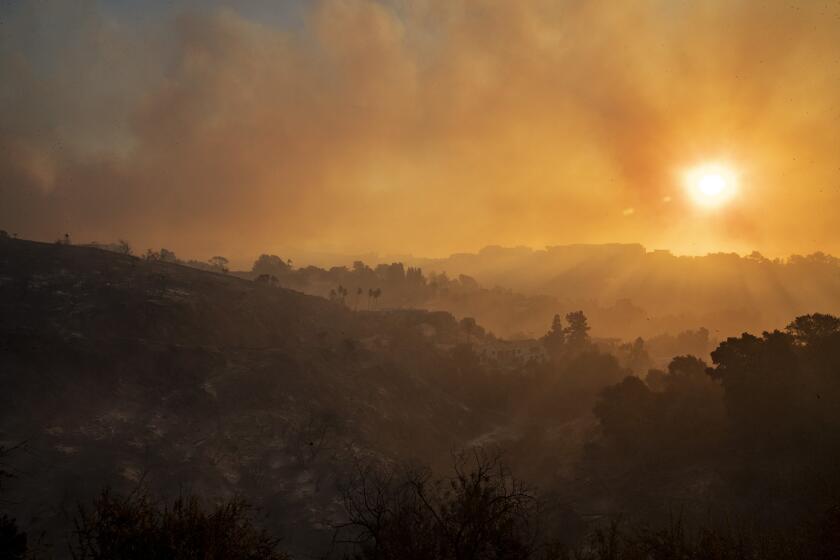LOS ANGELES, CALIF. -- MONDAY, OCTOBER 28, 2019: The sun rises over smoke filled canyon above the Getty museum as the Getty fire burns in Los Angeles, Calif., on Oct. 28, 2019. (Brian van der Brug / Los Angeles Times)