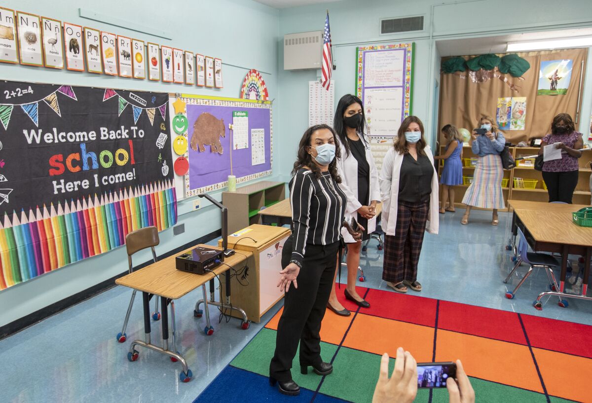 Doctors wearing face masks speak in a classroom
