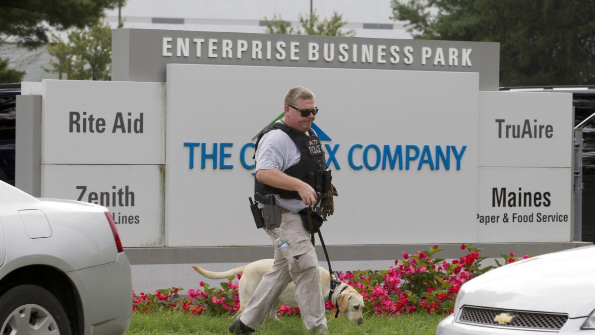 An officer with a sniffing dog walks out the industrial complex in Harford County, Md., Thursday, Sept. 20, 2018.