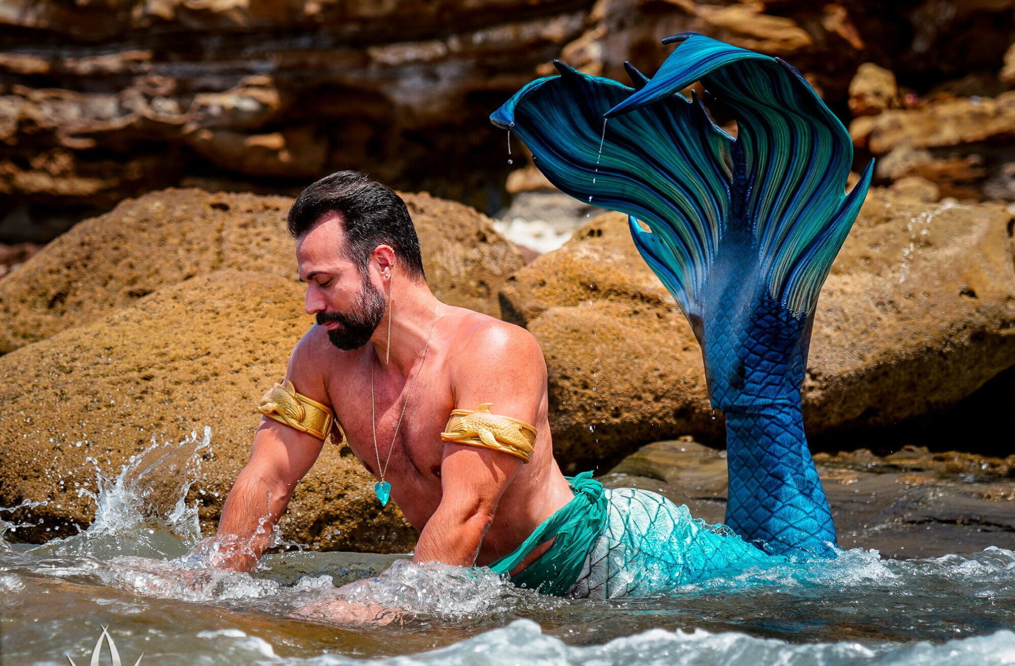 Jack Laflin wearing a merman costume while posing in a body of water