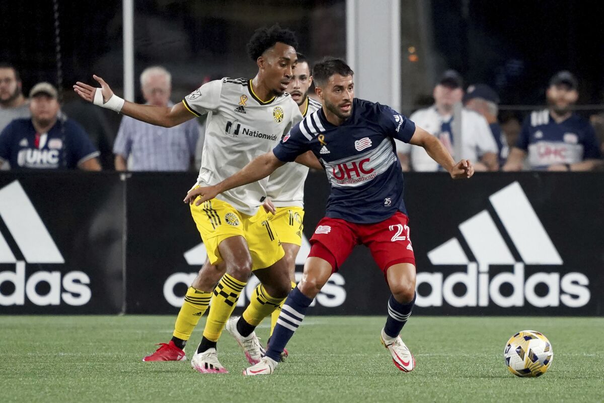 New England Revolution midfielder Carles Gil controls the ball ahead of Columbus Crew midfielder Marlon Hairston