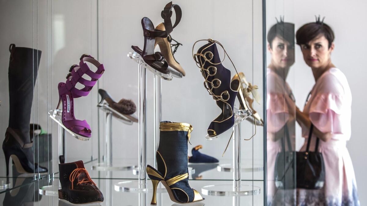 A visitor looks at creations by the founder of the eponymous high-end shoe brand Manolo Blahnik in an exhibition at the Museum Kampa in Prague, Czech Republic. The exhibition, with about 200 shoes created by Blahnik over 45 years, will be open to visitors through Nov. 12. (Martin Divisek / EPA)