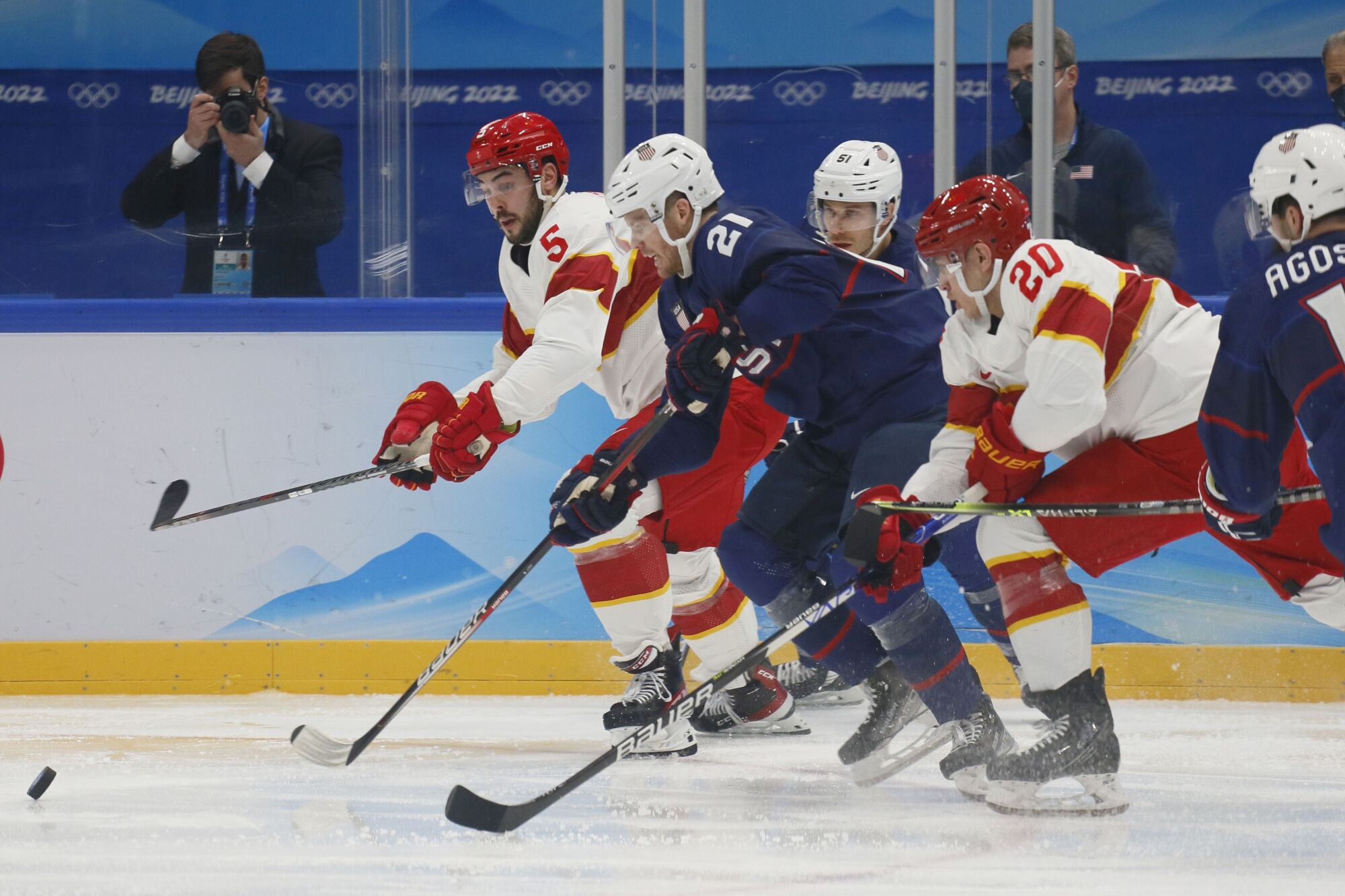 A scrum of U.S. and China players chase after the puck during a preliminary-round game at the Beijing Olympics.