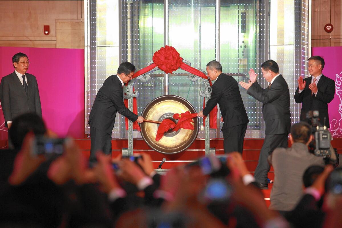 Xiao Gang, second left, head of the China Securities Regulatory Commission, and Shanghai Mayor Han Zheng, center, bang a gong to mark the opening of the Shanghai-Hong Kong Stock Connect, which opens China's capital markets to foreign investment.